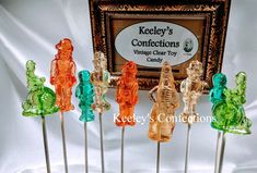 there are many small glass bears on the skewers in front of a sign