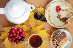 a table topped with plates and cups filled with food