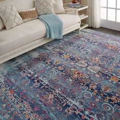 a living room area with a couch, rug and window sill in the background