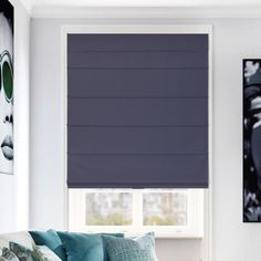 a living room filled with furniture and a window covered in blue roman blind coverings