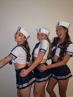 three girls dressed in sailor outfits posing for the camera