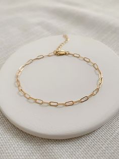 "Any fashion girl will tell you, a simple paperclip chain bracelet is a staple piece for your wardrobe! This is a shiny and versatile bracelet that looks beautiful everyday, or stacked with other gold bracelets for a more bold look! Made with chain sourced in the USA 💛 * 2.8x6mm 14K Gold Filled or 925 Sterling Silver chain * Dainty 14K Gold Filled or 925 Sterling Silver clasp * 14/20 gf stamp for authenticity * Choose your length (each bracelet comes with a .75\" extender chain for adjustable s Delicate Everyday Paperclip Bracelet, Minimalist 14k Gold Filled Paperclip Bracelet, Minimalist Gold Paperclip Bracelet, Minimalist Paperclip Chain Bracelet, Minimalist Adjustable Paperclip Bracelets, Adjustable Minimalist Paperclip Bracelet, Dainty Paperclip Chain Bracelet With Delicate Chain, Dainty Adjustable Paperclip Link Bracelet, Dainty Adjustable Paperclip Chain Link Bracelet