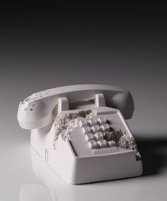 an old white telephone with some dirt on it