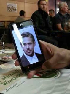 a person holding up a cell phone with a photo on it