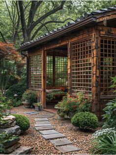 a small wooden building surrounded by trees and rocks in the middle of a garden area