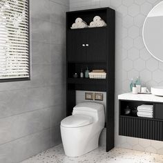 a white toilet sitting in a bathroom next to a black shelf with towels on it