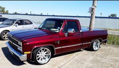 a red pickup truck parked in a parking lot