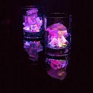 two glasses filled with ice and rocks in the dark