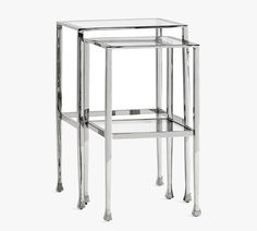 three glass tables with metal legs and one shelf on each side, all stacked together