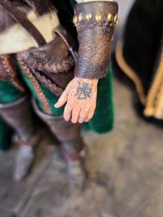 a close up of a person's arm and hand with tattoos on their arms