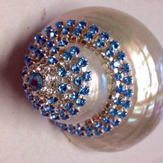 a close up view of a ring with blue and white stones on it's center