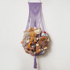 a purple bag filled with stuffed animals hanging from it's side on a wall