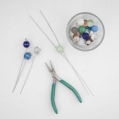 the scissors are next to some beads and needles