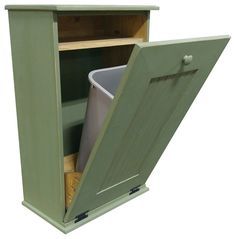 an open green cabinet with a trash can in it