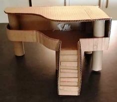 an open cardboard box sitting on top of a wooden table with stairs leading up to it