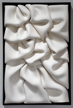 an art work with white fabric in a black box