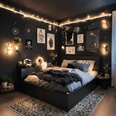 a bedroom with black walls and lights on the ceiling, bed in foreground is lit up by string lights