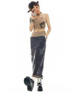 a young woman is talking on her cell phone while wearing black pants and a striped top