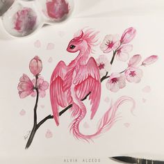 a pink bird sitting on top of a tree branch next to some watercolor paints