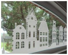 the window is decorated with white paper houses