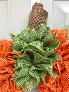 an orange and green burlocked wreath on the front door