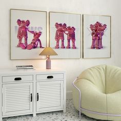 two framed pictures hang on the wall next to a white cabinet and pink chair in a room