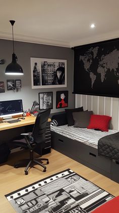 a bedroom with a bed, desk and computer on it in front of a black world map