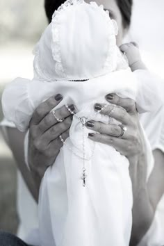 a black and white photo of a woman holding a baby in her arms with both hands