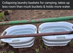 two buckets sitting next to each other on the ground with water in them and an old pipe nearby