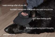 a black dog laying on top of a wooden floor next to a person wearing a hat