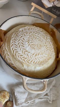 a round cake sitting in a pan on top of a table next to other items