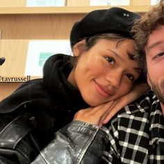 a man and woman are posing for a photo in front of a bookshelf