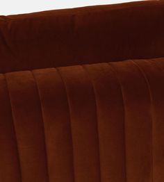 an orange velvet couch with pleating on the back