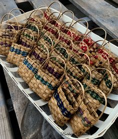 several baskets are lined up on a white platter with red, green, and blue ribbons