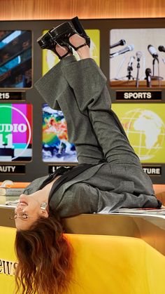 a woman laying on top of a table with her legs up in the air while wearing glasses