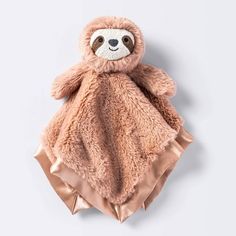 a stuffed slotty bear wrapped in a pink blanket on top of a white background