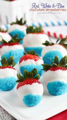 strawberries with blue and red sprinkles are arranged on a white plate