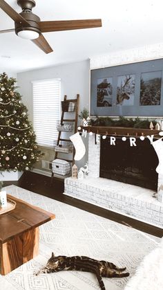 a living room filled with furniture and a christmas tree in front of a fire place