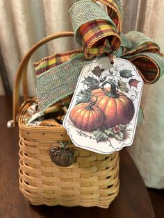 a wicker basket filled with pumpkins on top of a wooden table