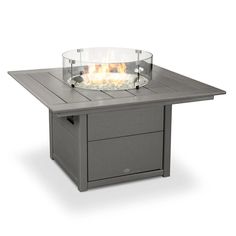 an outdoor fire table with a glass bowl on it's top and two drawers