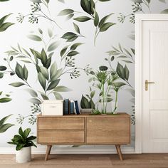 the wallpaper in this room is painted with green leaves and foliage, along with a plant