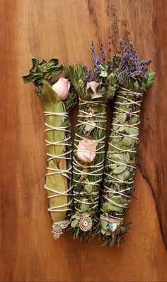 three bundles of flowers tied together on a wooden surface