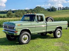 an old pick up truck parked in the grass