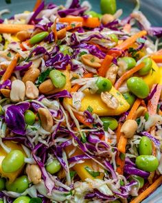 a colorful salad with carrots, cabbage, peas and cashews in a blue bowl