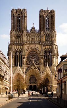 an old cathedral is shown in the middle of a street with buildings on both sides