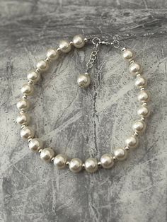 "Cream pearl anklet. Add a touch of elegance to your wardrobe with this timeless anklet. Handmade with love to elevate any look. 8mm faux pearls in a cream. The anklet is approximately 10\" and on a silver wire for strength. I have added an adjustable chain so can be altered to fit most. It closes with a lobster clasp. If you would like a different size making please just message me. Free shipping to UK buyers. I dispatch within 1-3 days but aim for next day postage with Royal Mail.  Presented on a gift card and wrapped beautifully in luxury tissue paper and a lovely organza bag to make the perfect gift.  Customer satisfaction is my main priority so if you are not completely in LOVE with your purchase, please let me know and you'll receive a stress free refund. Thank you for viewing. Pleas Elegant Pearl Anklets For Party, Elegant Adjustable Anklets With Pearl Charm, Elegant Adjustable Pearl Anklets, Elegant Silver Anklets With Pearl Chain, Elegant Pearl Anklets For Wedding, Elegant Pearl Anklets As Gift, Elegant Pearl Anklets With Pearl Chain, Elegant Pearl Chain Anklet For Party, Elegant Pearl Chain Anklets