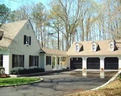 a white house with black garage doors and windows