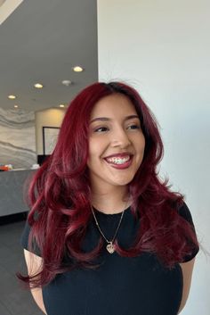 This vibrant deep cherry red hairstyle shows confidence and personal flair with its rich, shiny colors that reflect the light attractively. The hair flows in soft, full waves, giving the look a romantic and feminine vibe that's casually stylish. A gentle center-part allows the waves to surround the face evenly, adding a hint of - Click to see more of Turn Heads with These 28 Stunning Deep Cherry Red Hairstyles and follow us for more hairstyle ideas. // Photo Credit: Instagram @azulsbeauty Bright Red Hair On Brown Skin, Light Cherry Hair, Cherry Cola Short Hair, Cherry Red Hair On Brown Skin, Soft Red Hair, Red Hair On Brown Skin, Deep Cherry Red Hair, Cherry Red Hair Color, Red Hair Pale Skin