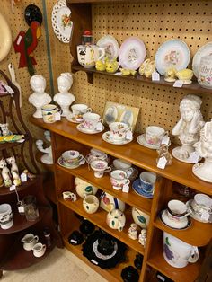 there are many plates and bowls on the shelves in this room, including one that is filled with figurines