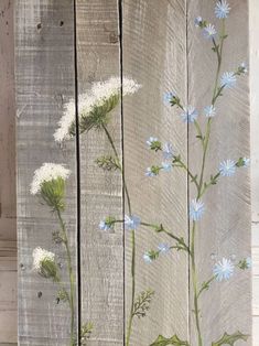 painted wood panels with blue and white flowers on the outside, along with green stems